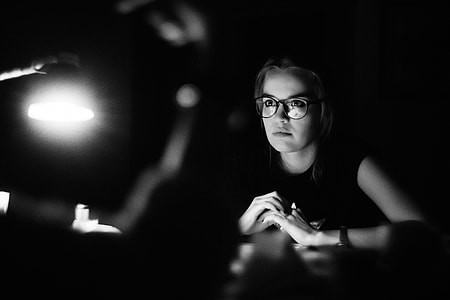 woman sitting wearing eyeglasses in grayscale photography thumbnail