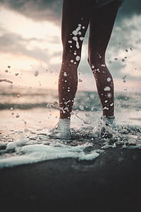 woman in white high-top sneakers standing on seashoe thumbnail