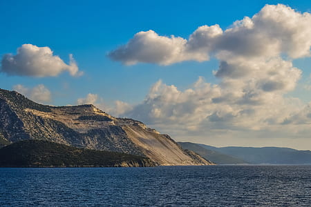 brown mountain under white clouds and blue sky thumbnail