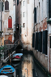 two blue boats beside brown concrete building thumbnail