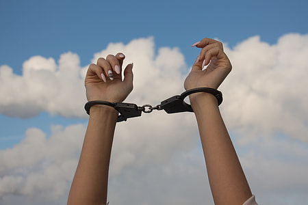 person's raised hands with handcuffs thumbnail