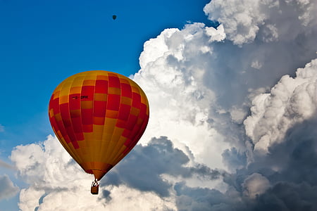 yellow and red hot air balloon near white sky during daytime thumbnail