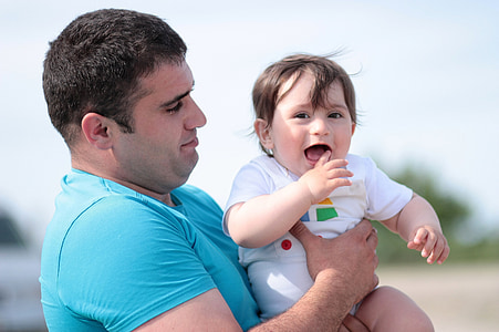 man lifting baby during daytime thumbnail