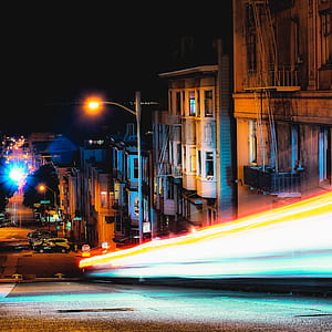 time lapse photography of vehicle near building thumbnail