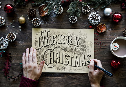 person writing Merry Christmas on white paper thumbnail