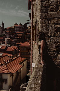 woman standing on balcony while watching houses thumbnail
