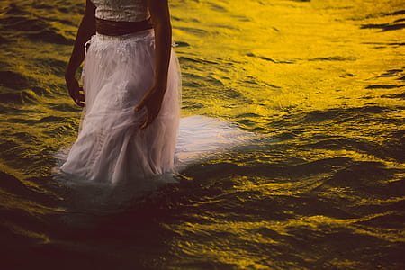 woman wearing dress walking on body of water thumbnail
