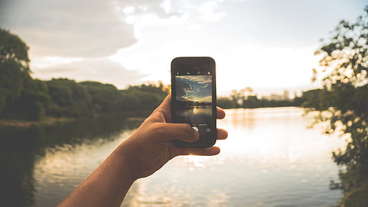 person holding smartphone doing photo of lake during daytime thumbnail