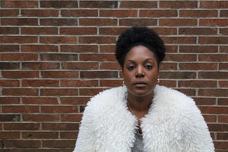 woman standing in front of brick wall thumbnail