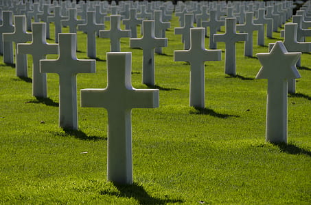 tomb stone with cross on grass field thumbnail