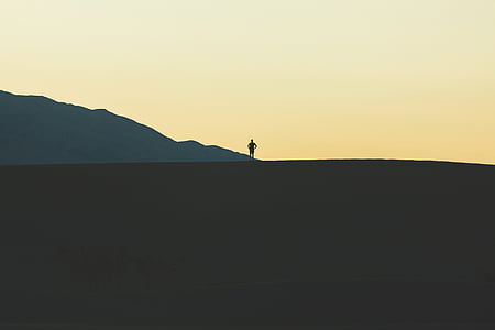 silhouette of man on top of mountain thumbnail