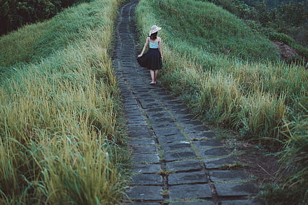 woman in between road and grass thumbnail