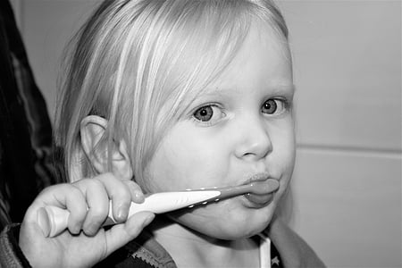 girl holding toothbrush grayscale photo thumbnail