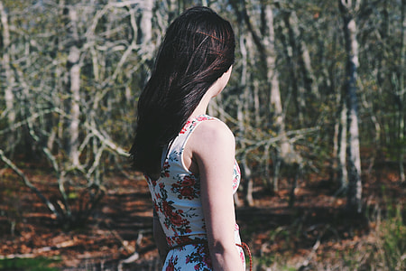 woman wearing white and red floral dress near bare trees at daytime thumbnail