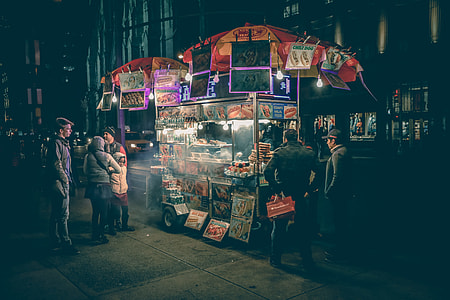 people gathered near the food cart at night thumbnail