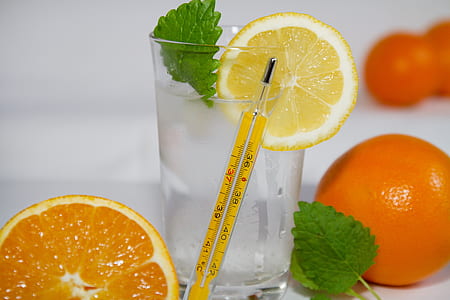 yellow thermometer beside glass of water with sliced lemon thumbnail