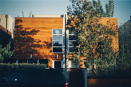 black SUV parked beside brown concrete house at daytime thumbnail