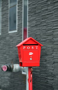 red mail box beside gray wall thumbnail