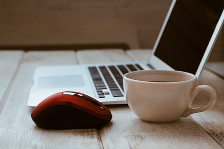 red and black wireless mouse and white ceramic cup thumbnail