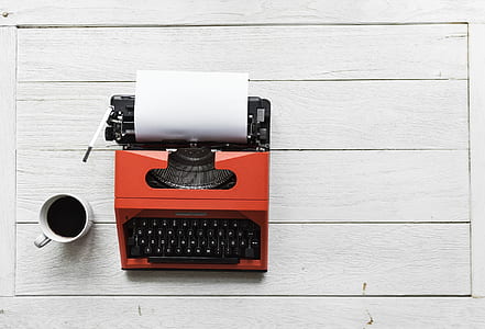 red typewriter on top of white board thumbnail