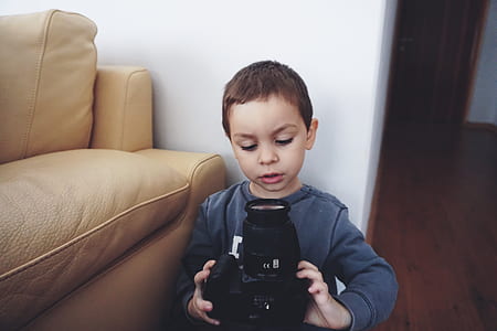 Boy Holding Black Dslr Camera thumbnail