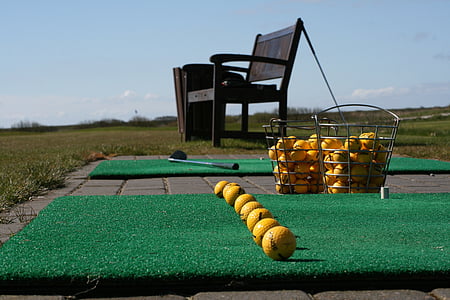 yellow golf balls near black wooden bench thumbnail