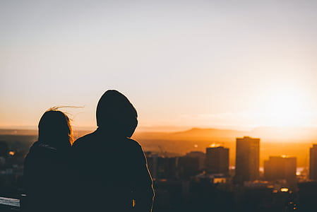 silhouette photo of man and woman on top building thumbnail
