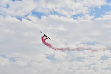 black and red fly past plane at day time thumbnail