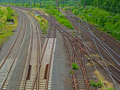 brown train track with green grass at daytime thumbnail
