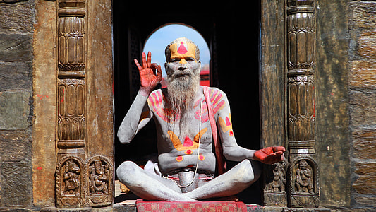 close up photo man in red body hand paint sitting in door thumbnail