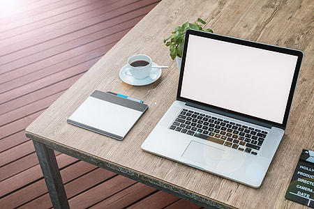 MacBook Pro on brown wooden table thumbnail