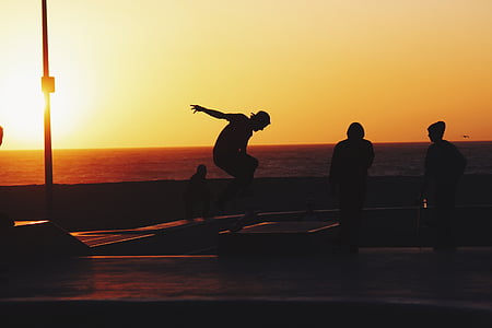 four person silhouette near sea at golden hour thumbnail
