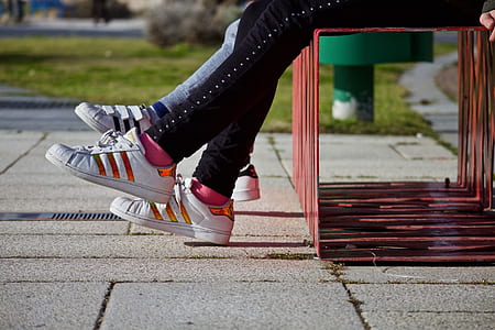 two people sitting on bench with feet raised at daytime thumbnail