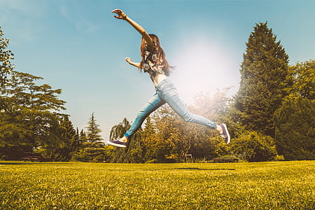 Happy young girl jumping in the park at summer thumbnail