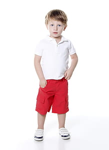 boy wearing white polo shirt and red cargo shorts standing on white surface thumbnail