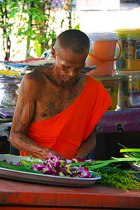 man in front purple orchids in oval gray tray thumbnail
