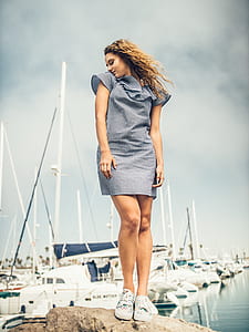 woman standing on brown stone near pier thumbnail
