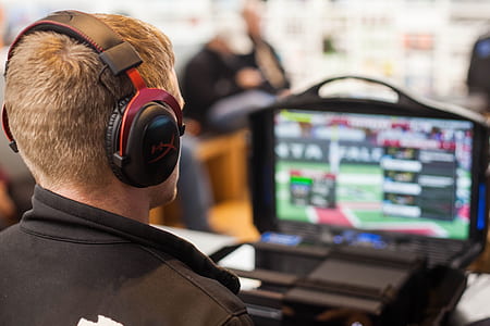 man wearing black wireless headphones on front of monitor thumbnail