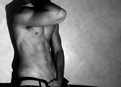 topless man leaning on wall for photo shoot thumbnail