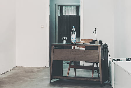 clear glass bottle on brown wooden desk thumbnail