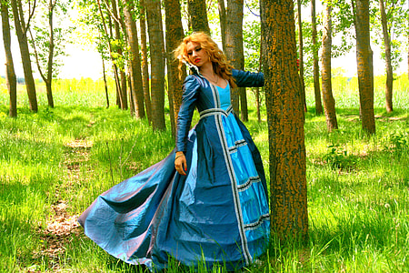 woman wearing blue dress under trees thumbnail