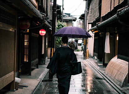 Woman Using Purple Umbrella Walking in the Street thumbnail
