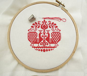 red and white cross titch decor on top of white textile thumbnail