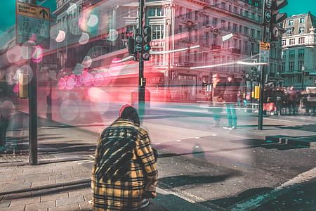 time lapse photography of kneeling man near traffic lights thumbnail