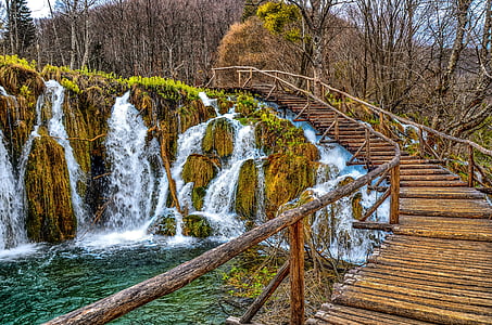brown bridge in forest with waterfalls thumbnail
