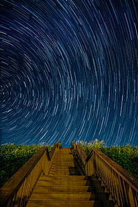 brown stairs under starry night time lapse photography thumbnail