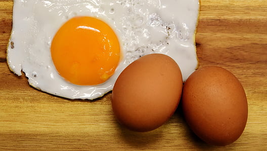sun side up fried egg beside two eggs on board thumbnail