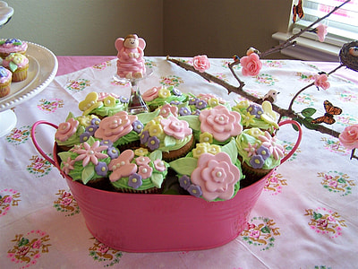 assorted cupcakes in pink container on table thumbnail