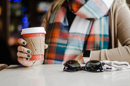 human holding disposable cup near sunglasses thumbnail