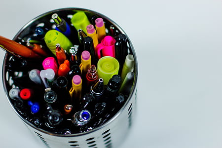 assorted-color pens in cylindrical grey holder thumbnail